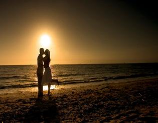 Lovers kissing under sunset near beach